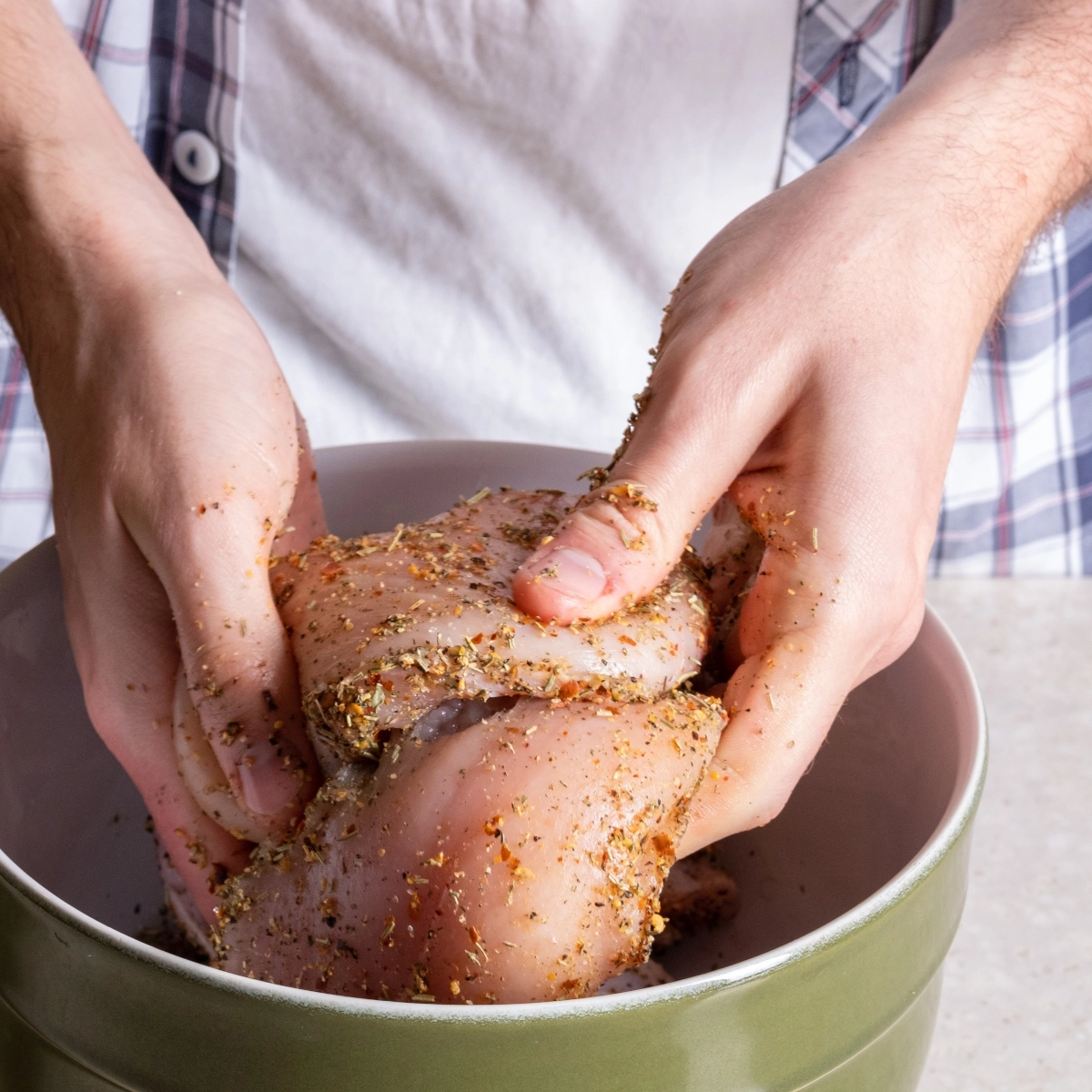 Chicken marinating in spices and herbs in glass bowl for grilling