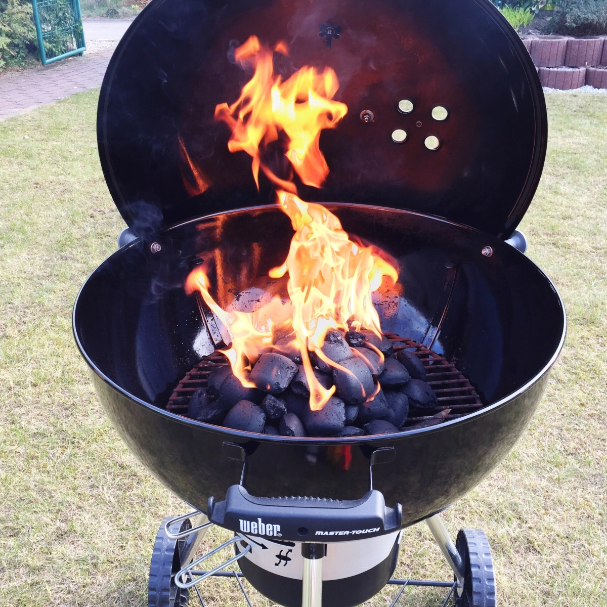Charcoal grill with two-zone heat setup for direct and indirect cooking.