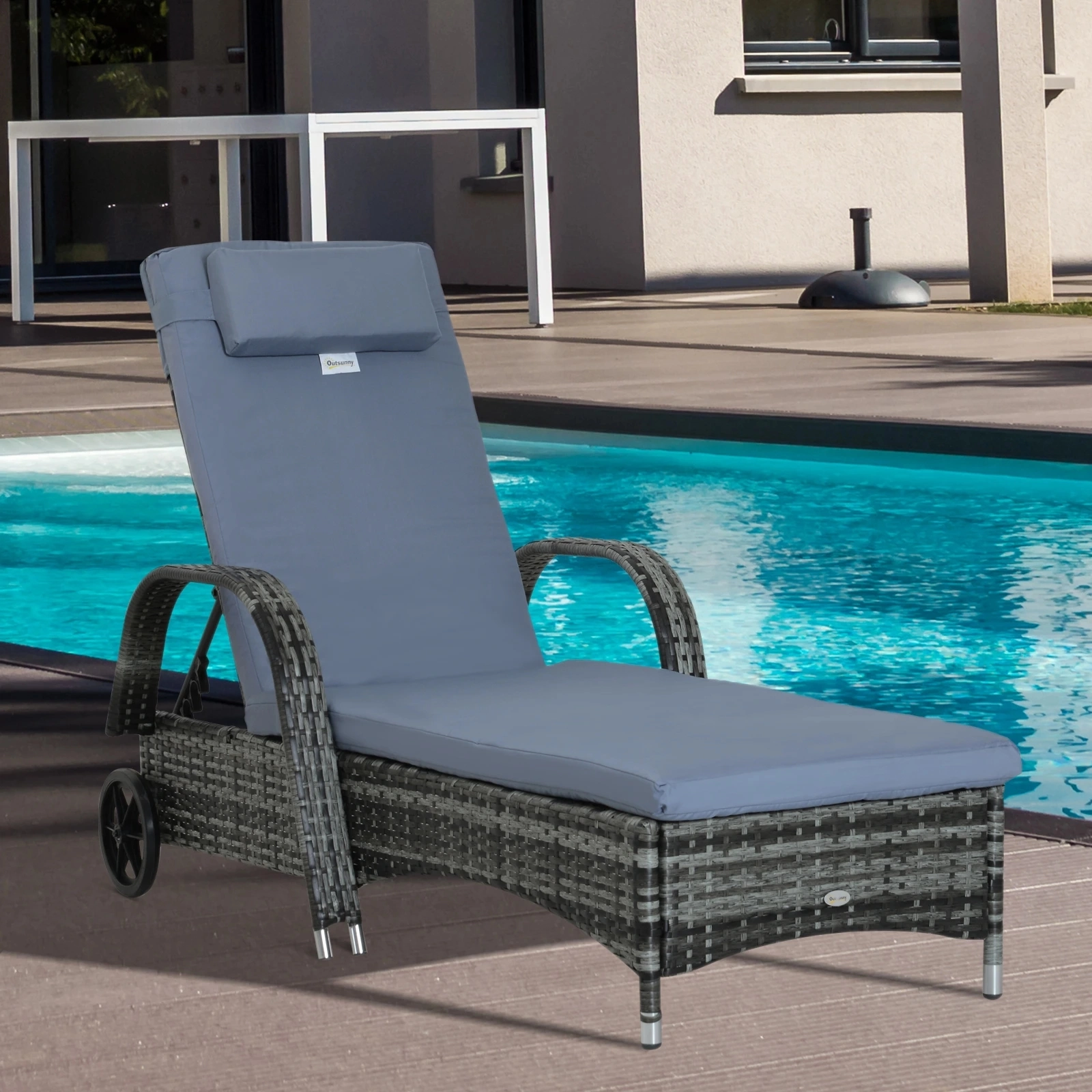 Rattan lounge chair with wheels and blue cushion placed on a wooden deck beside a pool.