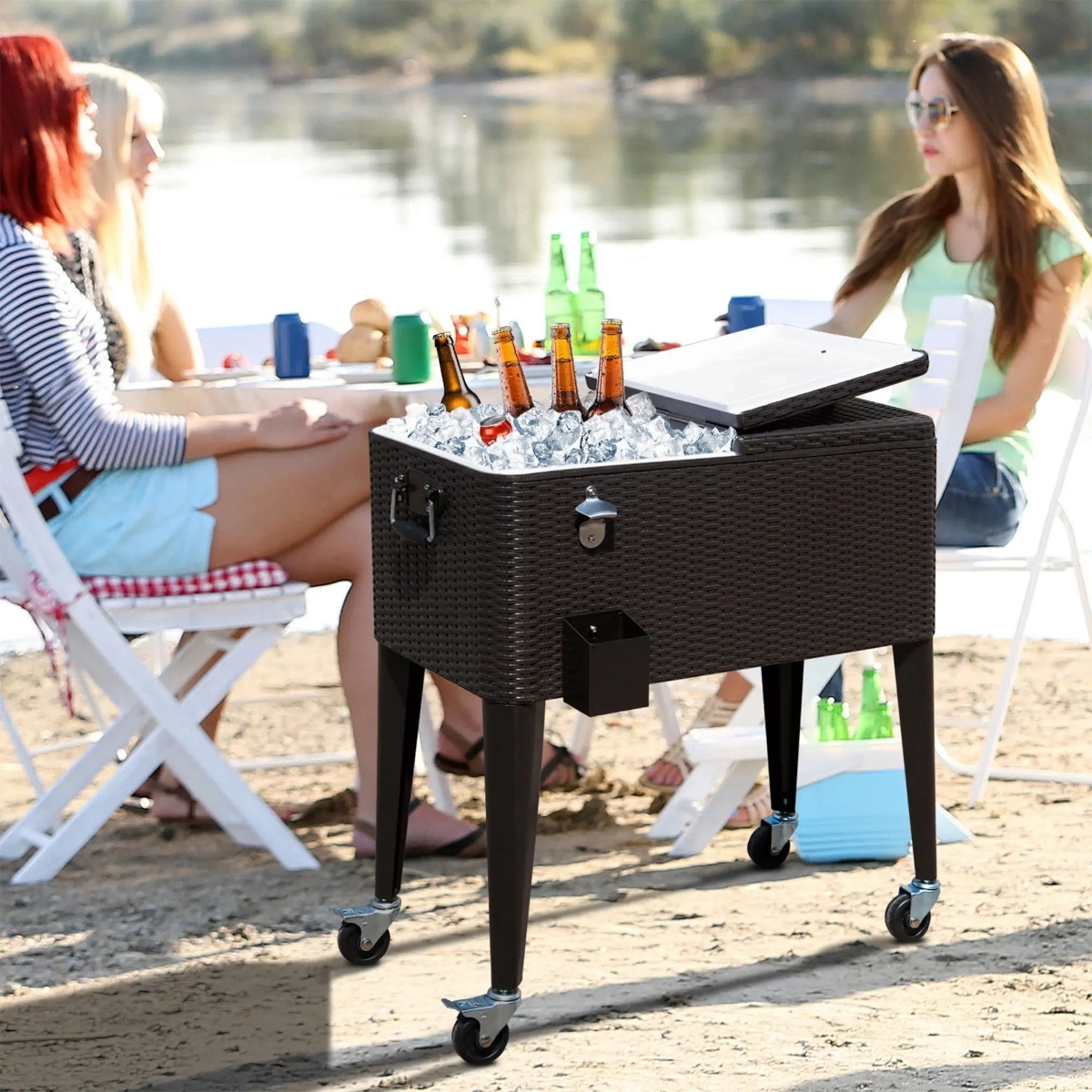 Outdoor picnic scene with friends and wicker cooler cart filled with ice and drinks.