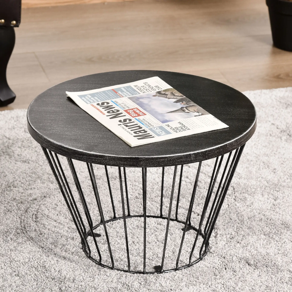 Modern hourglass steel side table with a sleek black finish and clean lines.