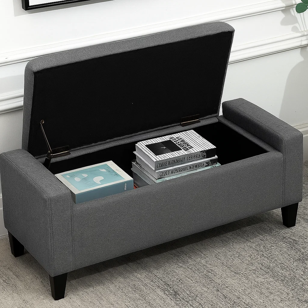 Gray ottoman bench with open lid, showing neatly stacked books and magazines inside.