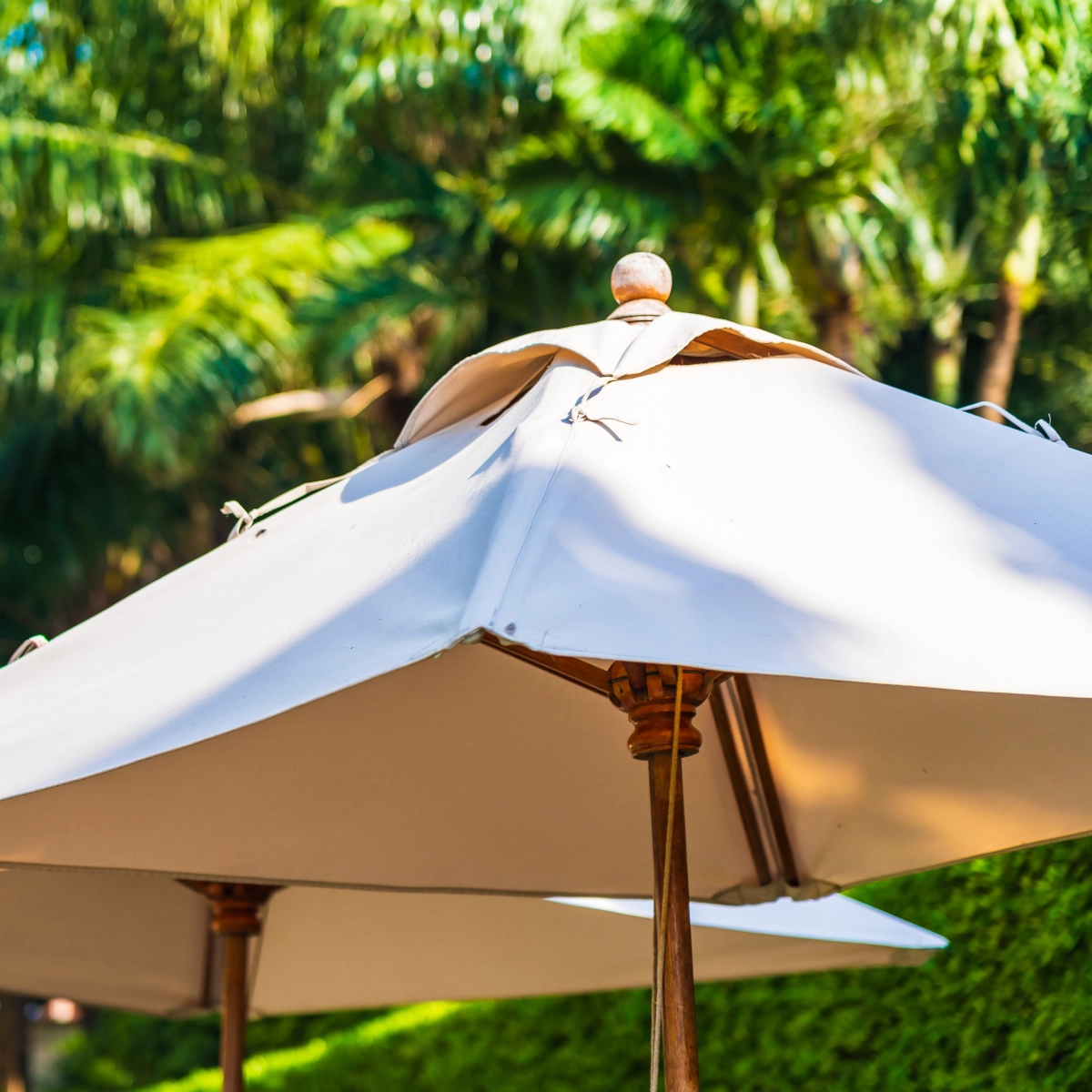 Close-up of beige patio umbrella canopy fabric with vented top for airflow and durability.