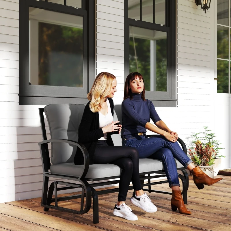 Cushioned two-person glider chair for cozy outdoor seating and gentle rocking motion.