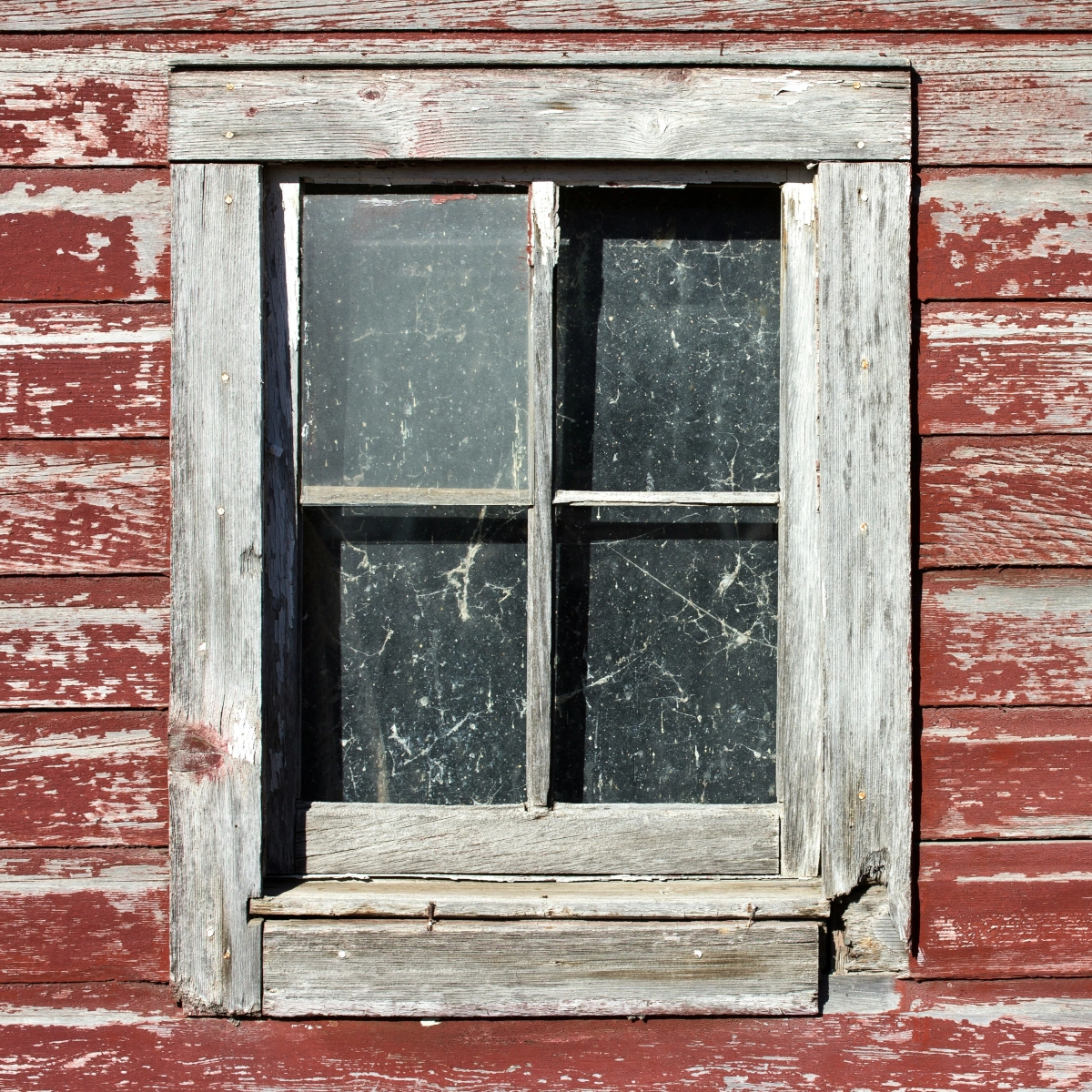 Close-up of repairing damaged shed door frame and sealing leaky window gaps for protection.