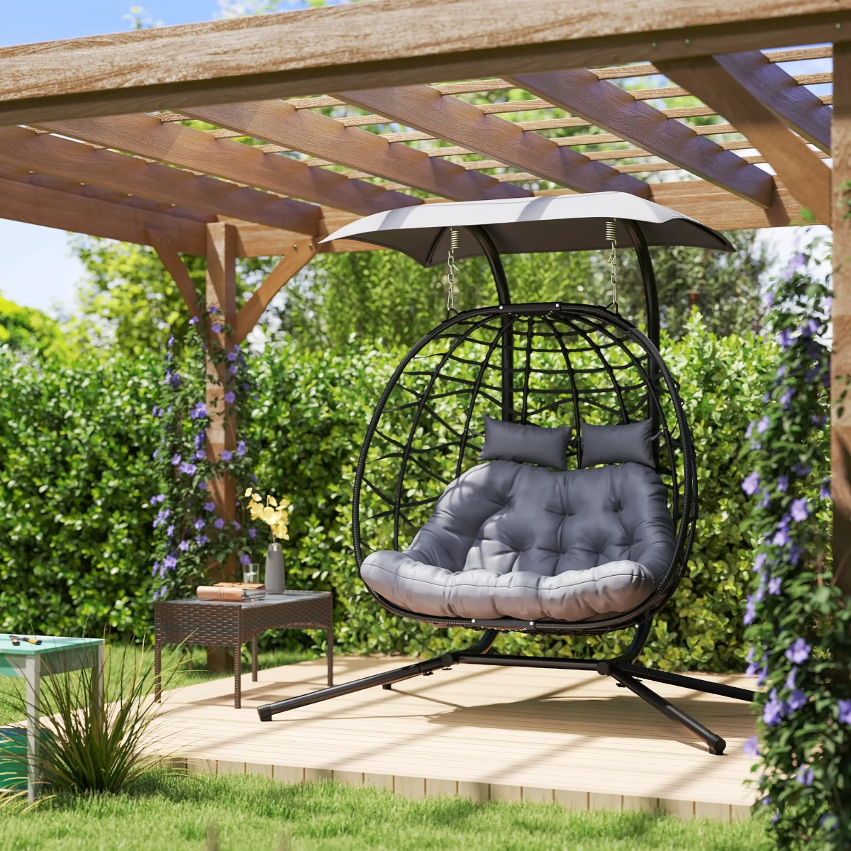 Outdoor double egg swing chair with canopy and cushions for shaded garden relaxation.