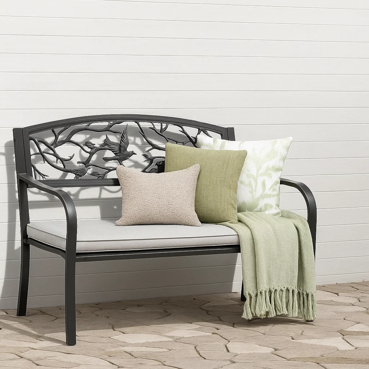 Colorful cushions and soft throws arranged on a garden bench for added comfort.