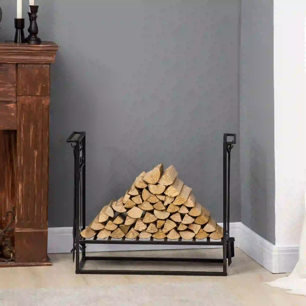 Indoor firewood rack with neatly stacked logs and fireplace tools placed beside a wooden mantel.