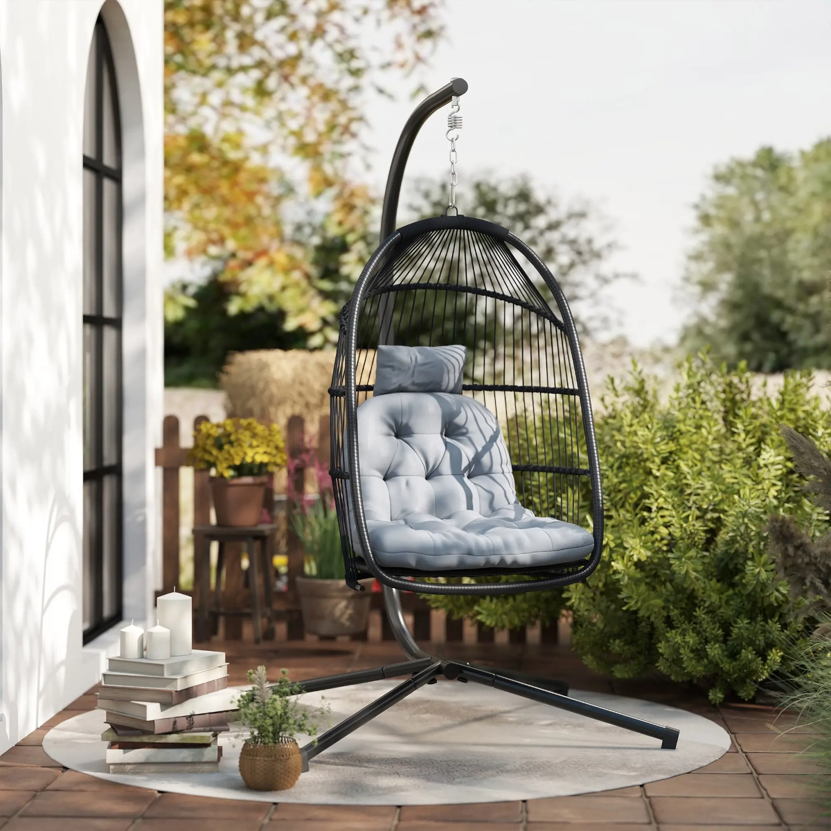 Hanging egg chair with foldable stand and cushion, ideal for balconies or small patios.