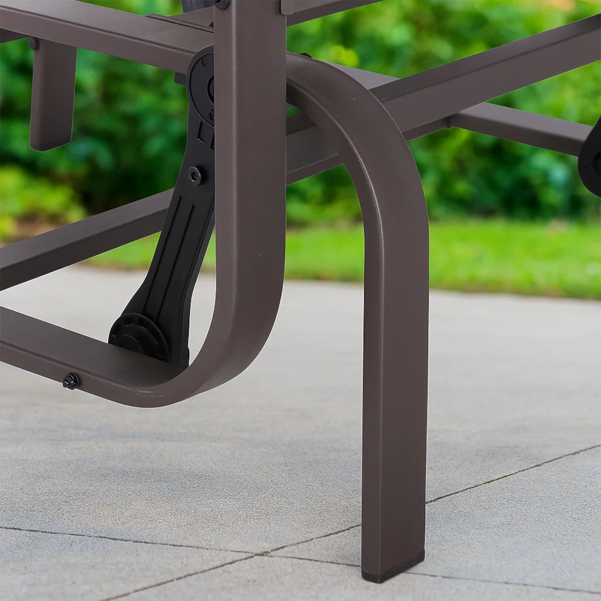 Close-up of glider chair leg and support mechanism on patio for stability and safety.