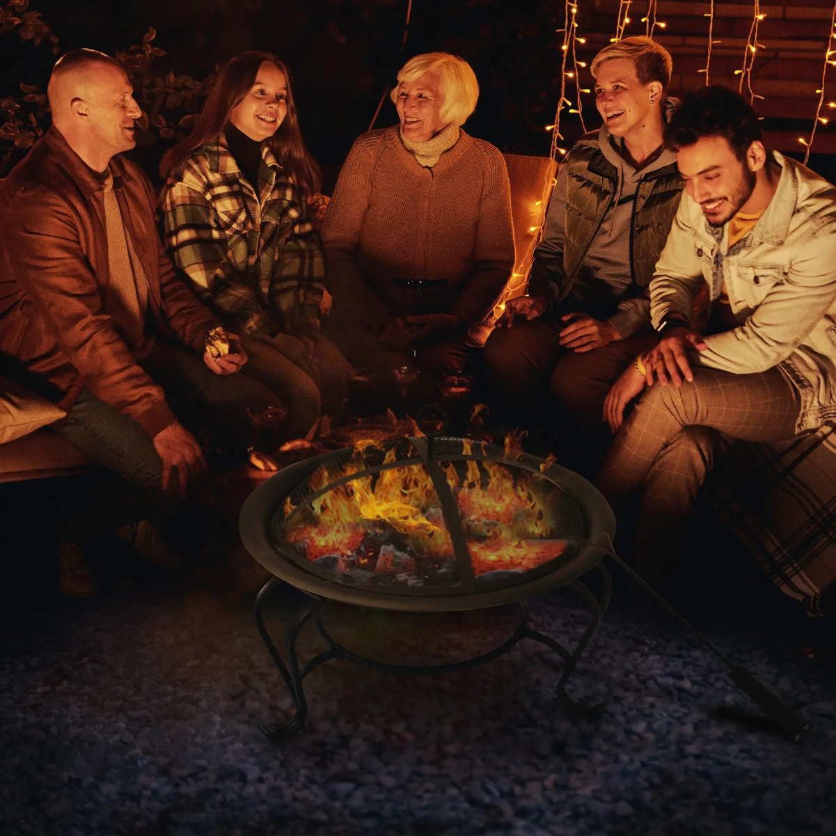 Modern backyard fire pit with flames surrounded by Adirondack chairs on a stone patio at dusk