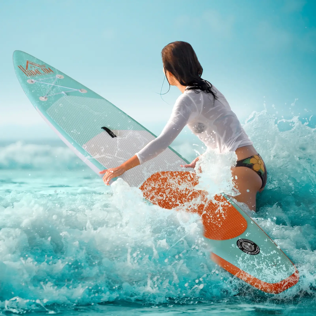 Woman paddling on a colorful inflatable SUP, cutting through small waves on the ocean.