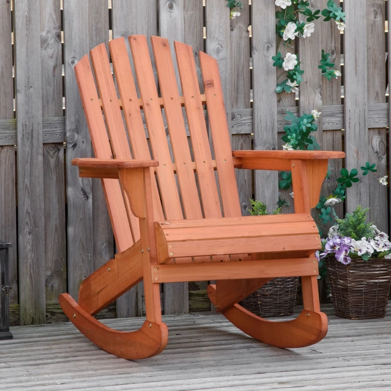Wooden outdoor rocking chair on a deck, surrounded by potted flowers and a wooden fence.
