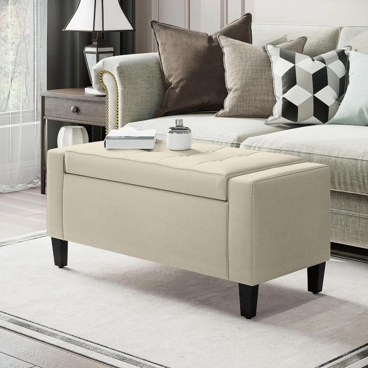 Beige upholstered ottoman placed in front of a sofa in a stylish living room.