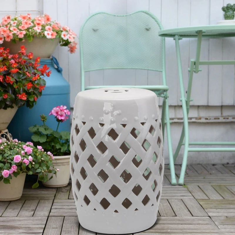  Outdoor patio with a white garden stool, vintage mint green bistro set, and blooming flower pots.