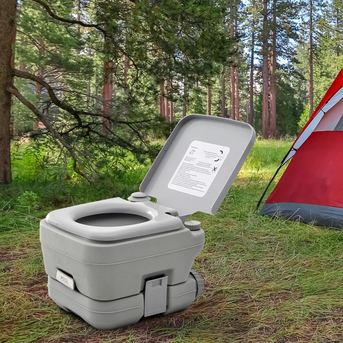 Compact outdoor portable toilet next to a camping tent in nature.