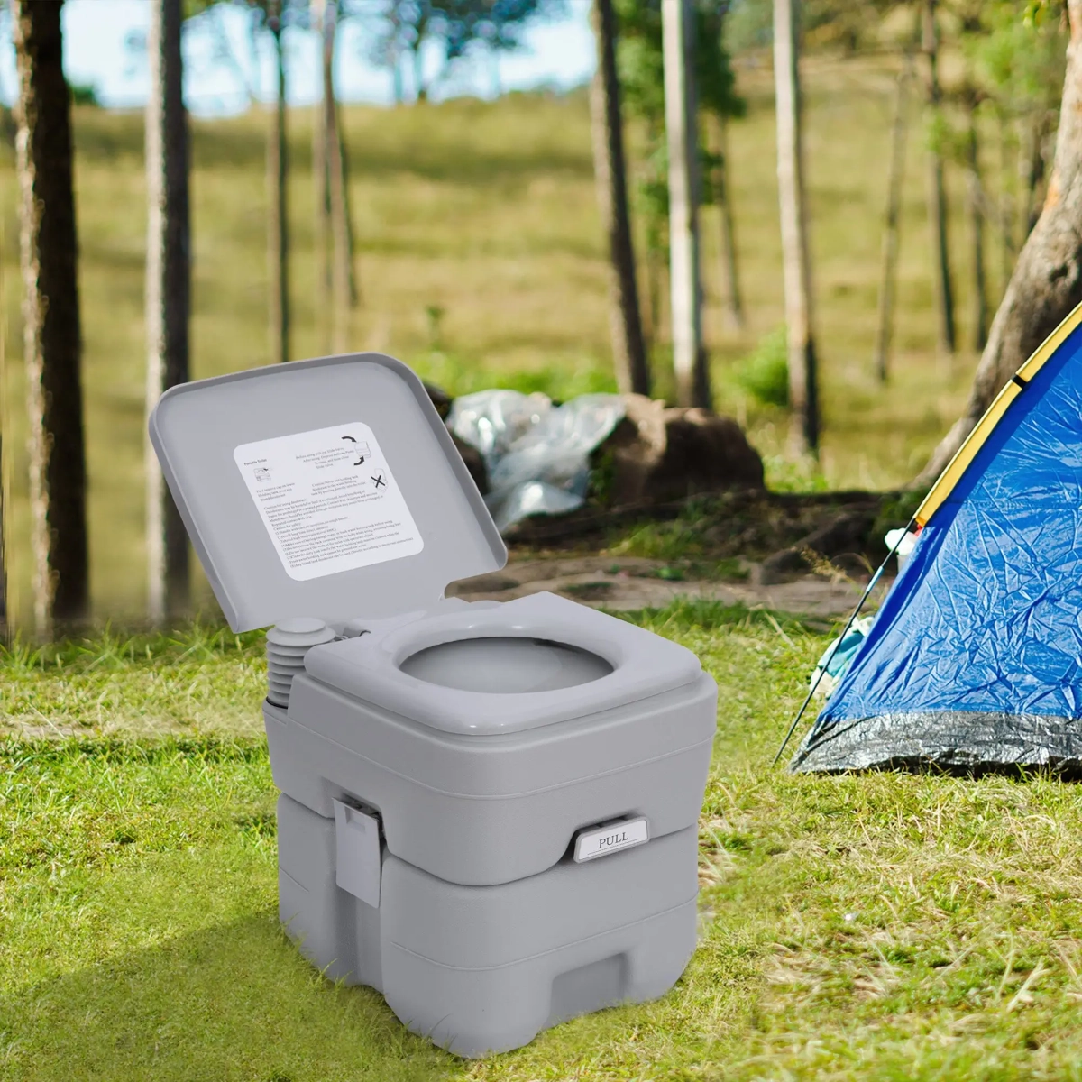 Large outdoor portable travel toilet beside a tent in a forest.