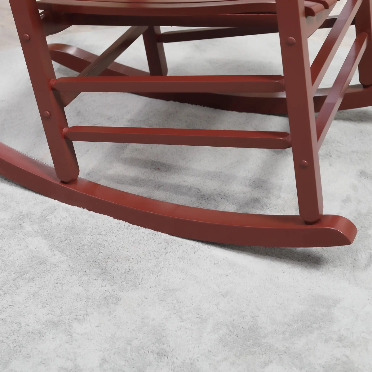 Red wooden rocking chair base shown on carpet highlighting its curved safety rockers.