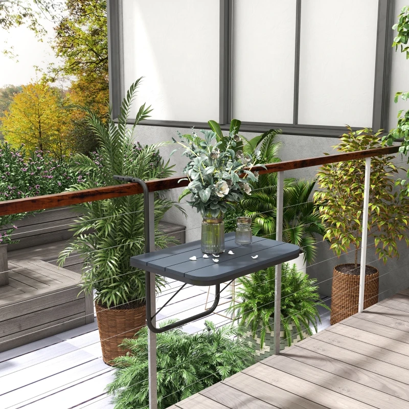 Modern balcony table with flower vase and glass jars, surrounded by lush outdoor plants.
