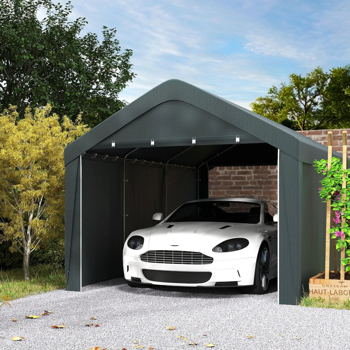 White Aston Martin parked in a dark gray tent-style carport with gabled roof and sidewalls.