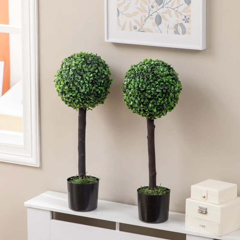 Triple ball topiary in black pot beside a modern grey chair.