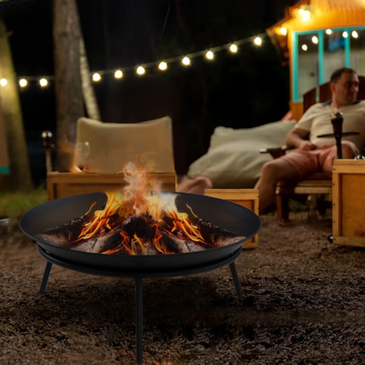 Square fire pit table with wicker-style base on backyard patio, surrounded by coffee mugs and chairs.