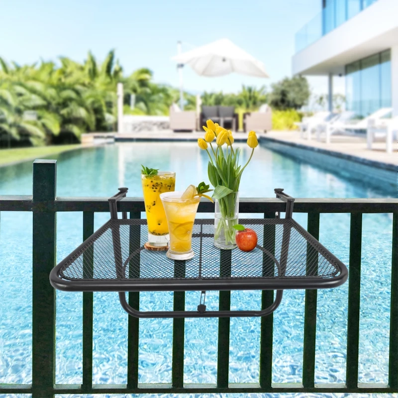 Black mesh balcony table with drinks, tulips, and apple, overlooking pool and outdoor lounge area.