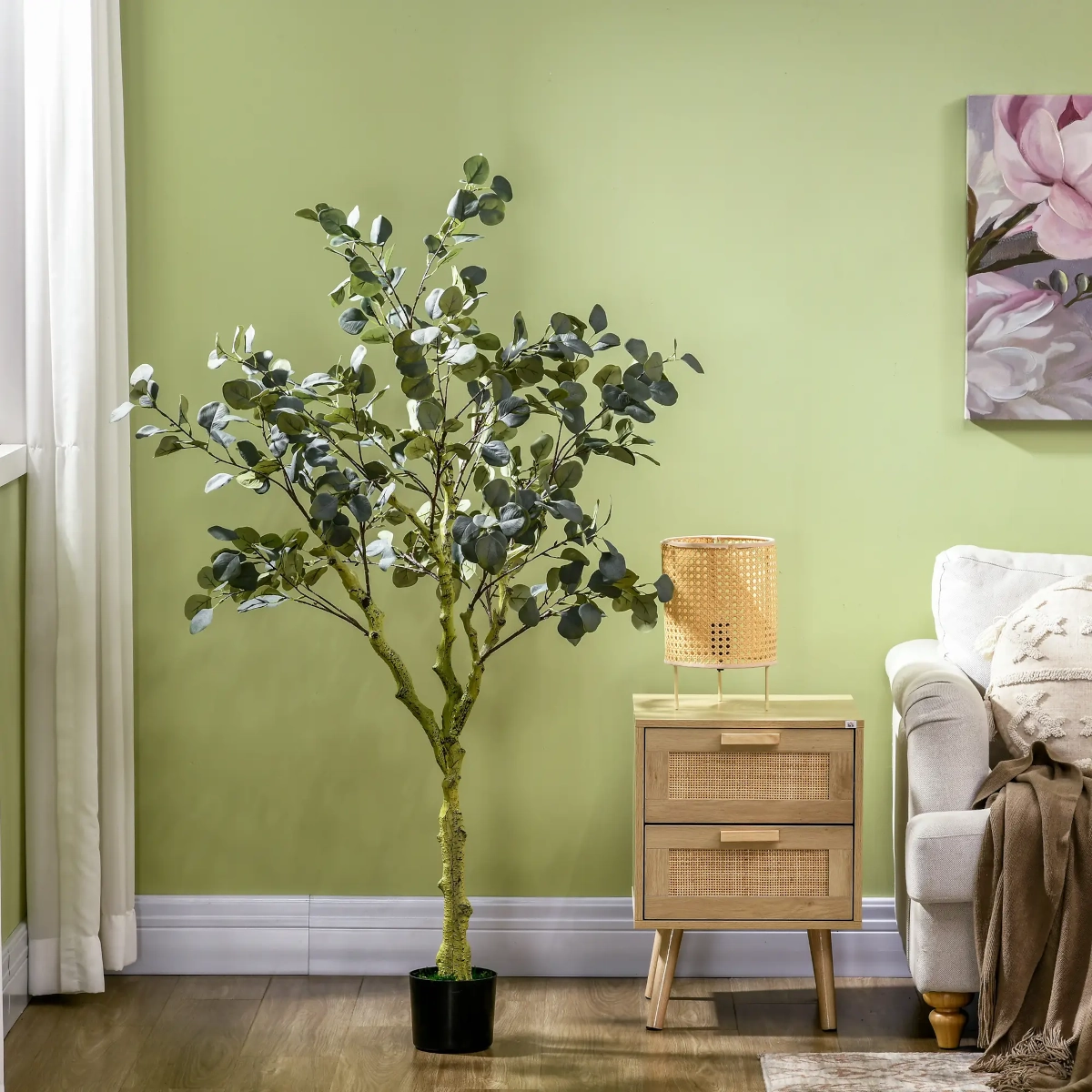 Snow-covered artificial tree between modern grey and cream furniture setup.