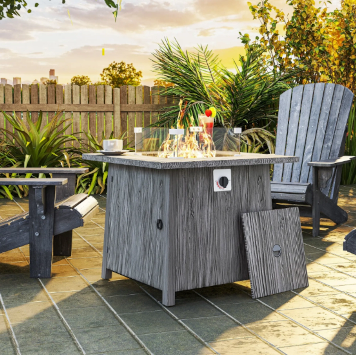 Gray wood-look fire table on patio surrounded by chairs, plants, and warm evening sunlight.
