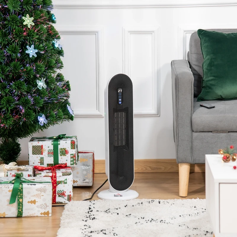 Ceramic tower heater placed beside a sofa and Christmas tree with wrapped gifts.