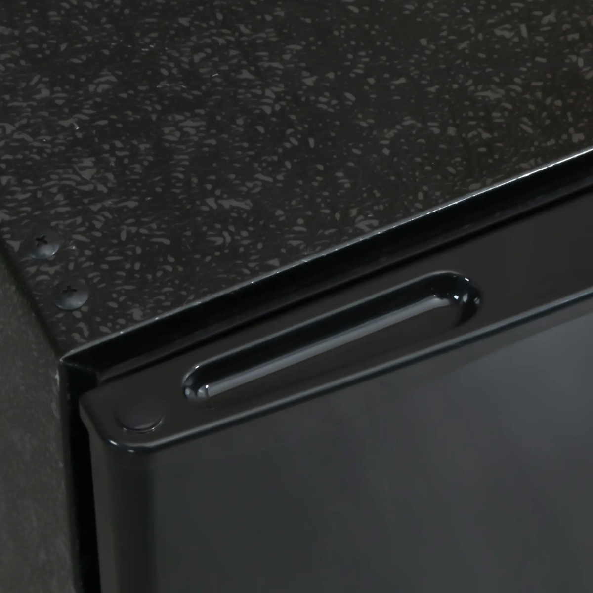 Close-up of black fridge corner and recessed handle