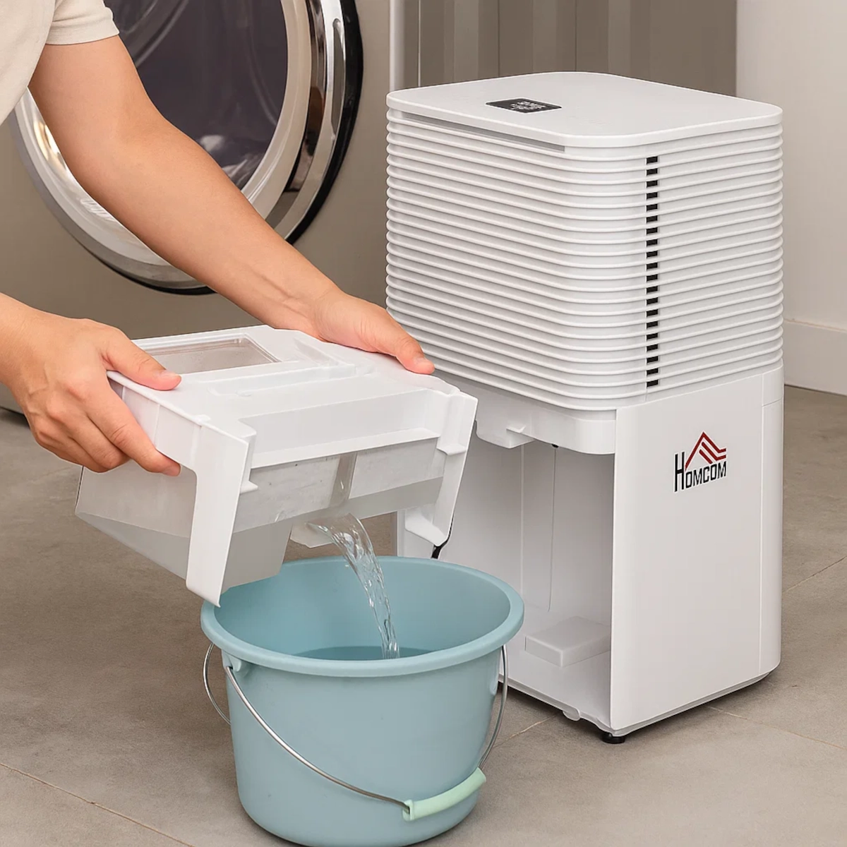 Person pouring water from HOMCOM dehumidifier tank into a blue bucket.