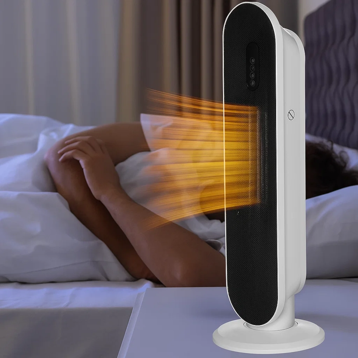 Ceramic tower heater emitting warm airflow beside a person resting in bed.