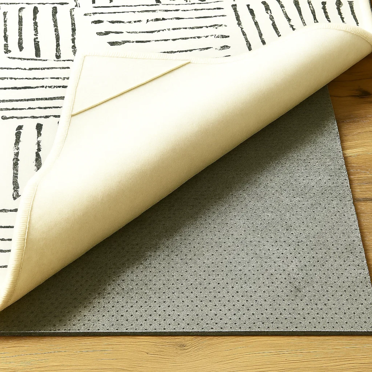 Felt rug pad placed under an area rug on hardwood floor for added cushion and grip.