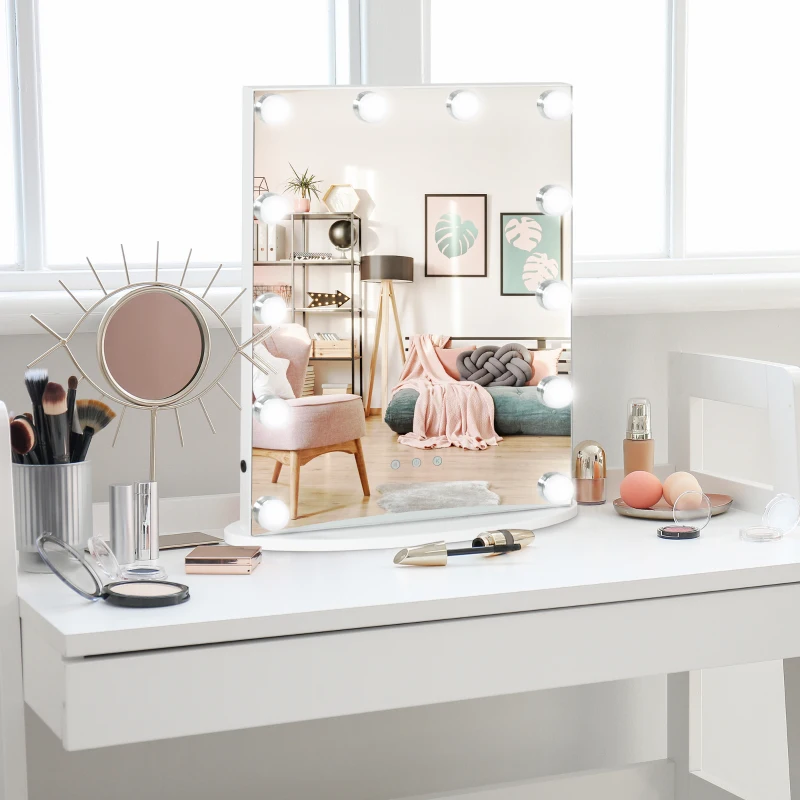 White vanity table with Hollywood bulb mirror, drawers, and shelves styled with beauty products.