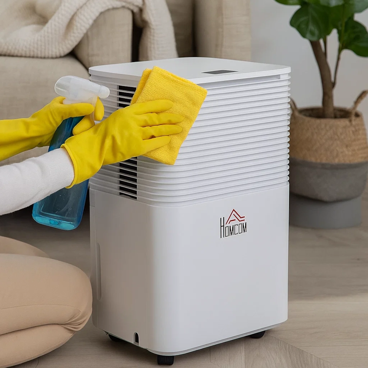 Wiping dehumidifier exterior with spray bottle and cloth.