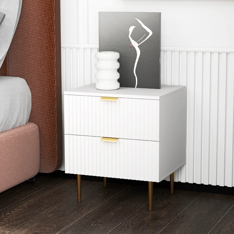 White modern bedside table with decorative vase and artwork.