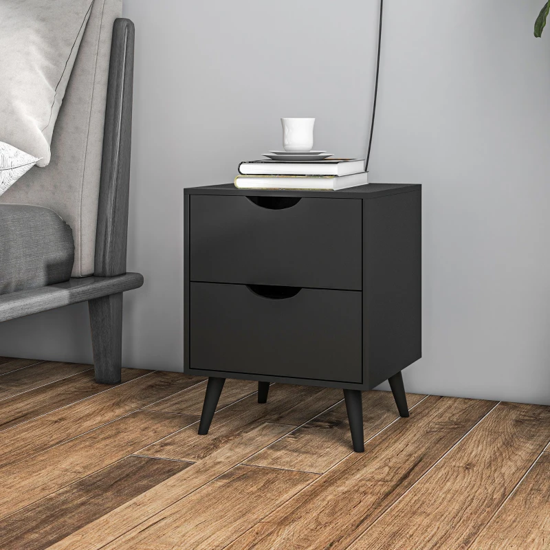 Black modern bedside table with two drawers, styled with books and cup beside bed.