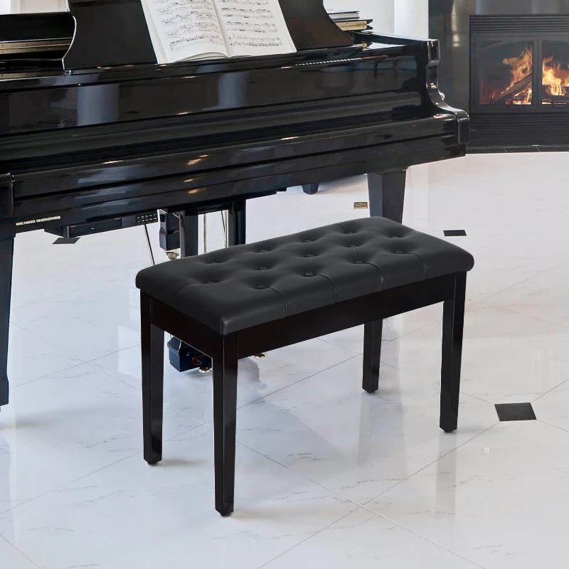 Black tufted leather piano bench positioned beside a grand piano