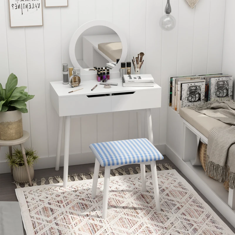 White vanity desk with round mirror, stool, and makeup neatly arranged.