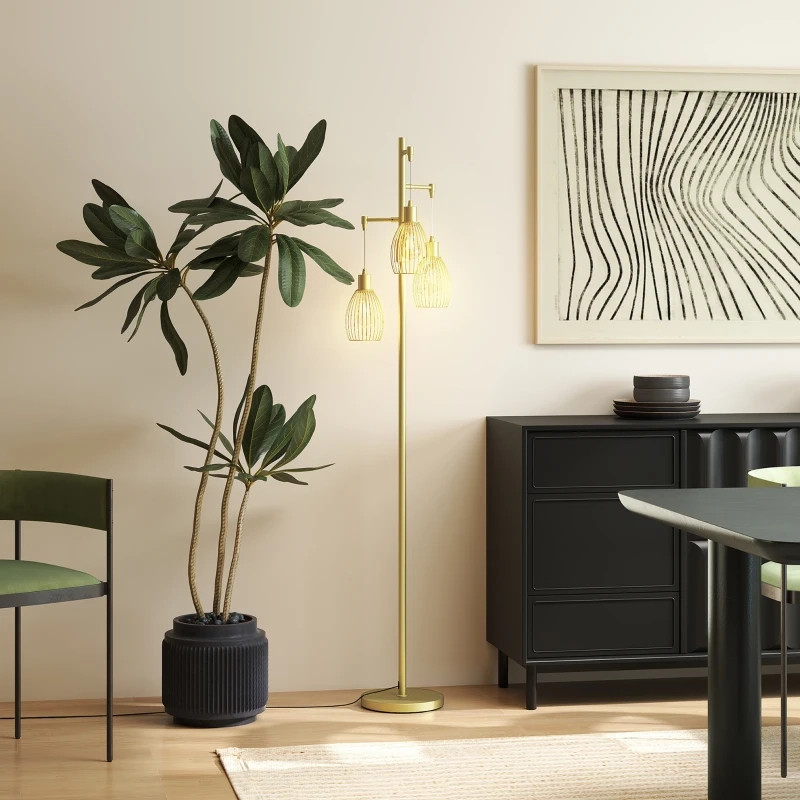 Modern living room with gold industrial cage floor lamp beside tall plant and black cabinet.