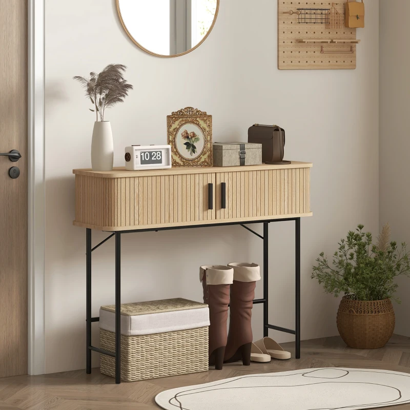 Natural wood console table with vertical fluting and black legs in a cozy entryway.