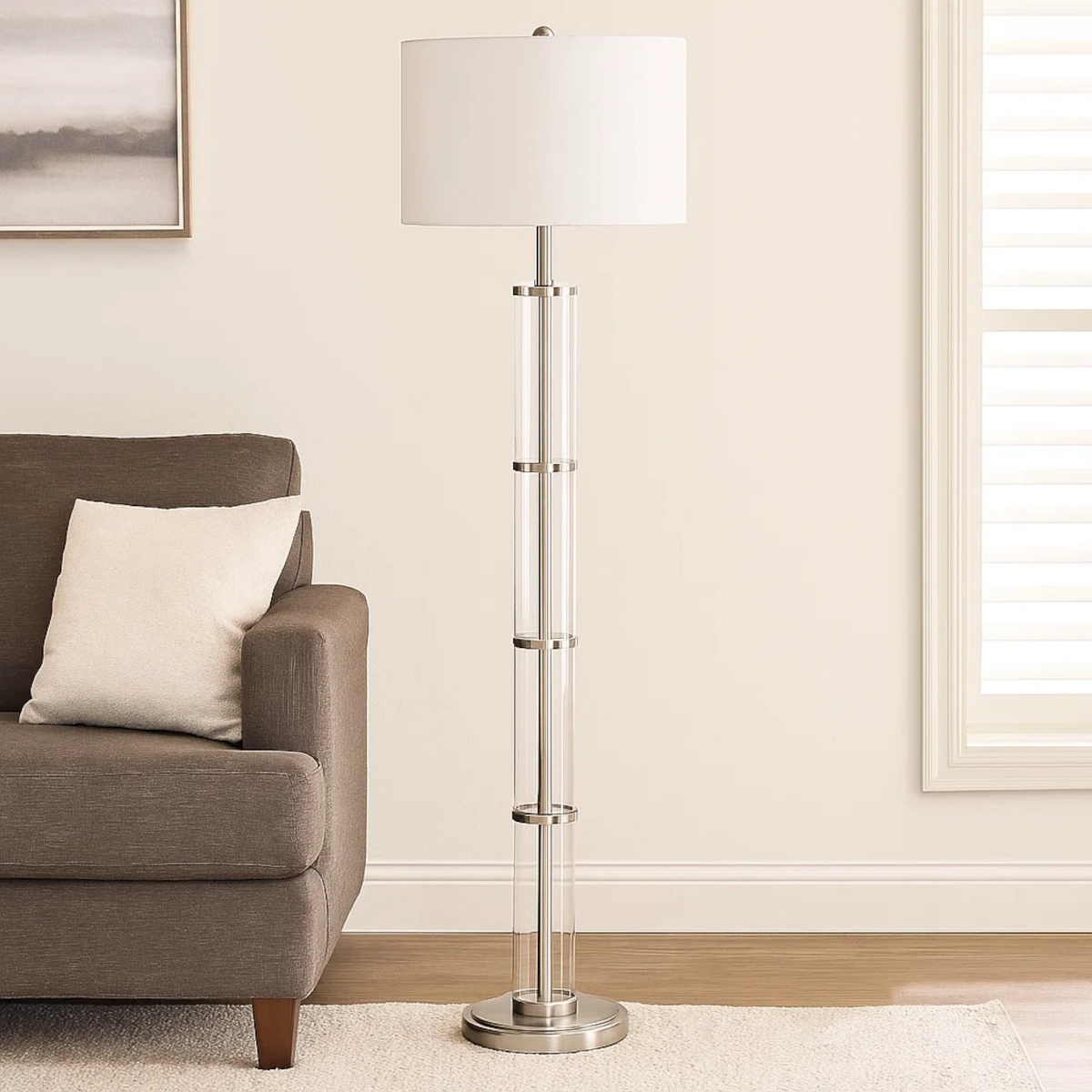 Elegant living room with Nimbus brushed nickel floor lamp and clear glass body beside sofa.