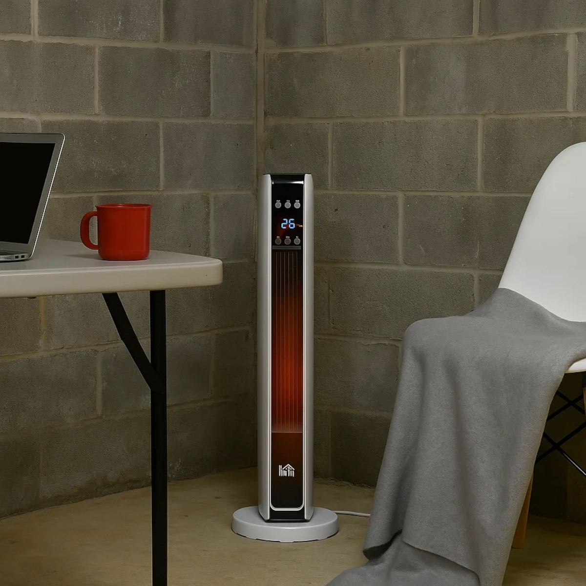Space heater warming a basement workspace with table, laptop, and red mug.