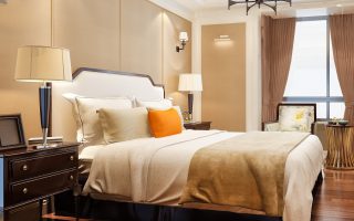 Elegant bedroom with soft lighting, cozy bedding, and decorative pillows.