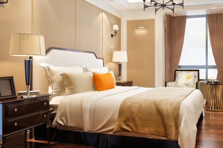 Elegant bedroom with soft lighting, cozy bedding, and decorative pillows.